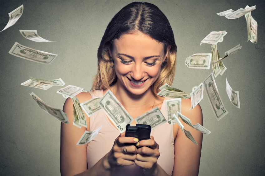 Happy woman using smartphone with dollar bills flying away from