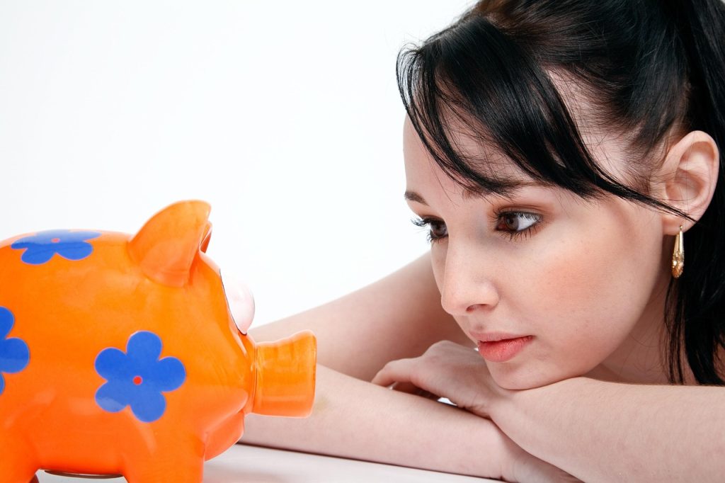 woman looking at piggy bank