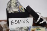 Gift package with dollars on the table on a white background, the inscription Bonus
