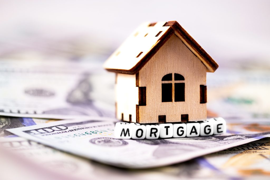 finance concept in blocks with word Mortgage and wooden symbol