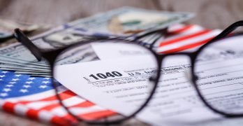 Income tax with instruction, money, calculator and glasses. Tax payment and filing concept