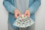 Businessman in blue shirt holds american dollars money on white