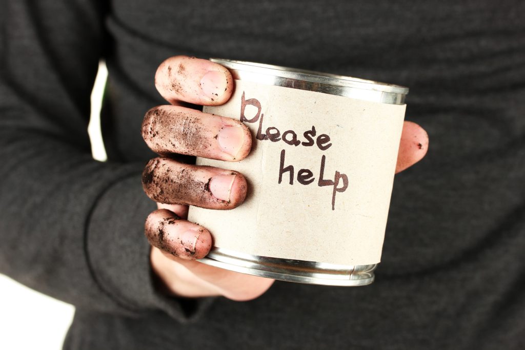 homeless man asks for help, on black background close-up