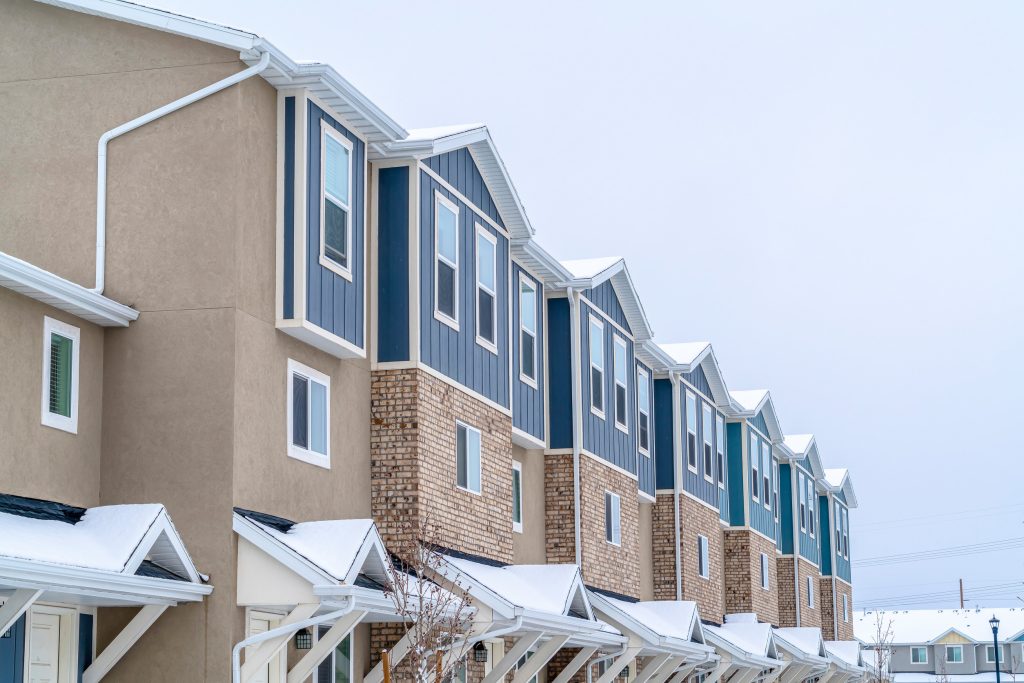 Apartment building with covered entrances against cloudy sky on a winter day