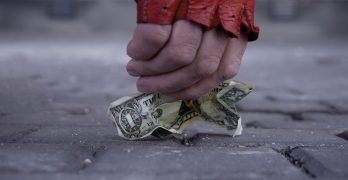 person picking up money off ground