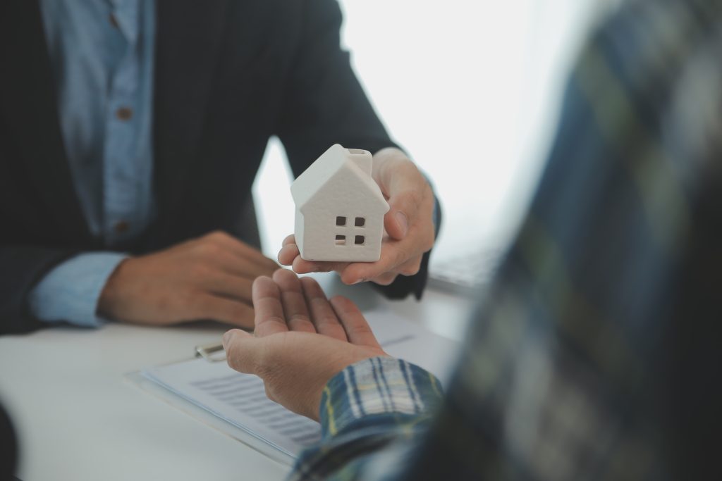 Real estate agent and customer signing contract to buy house