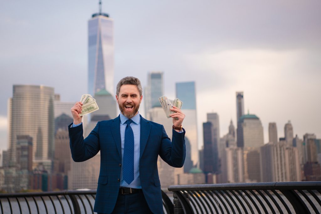 Businessman hold money dollars in New York. Businessman with dollar outdoor. Wealth rich businessman millionaire in suit holding money dollars . Winner, success with dollars. Finance and banking.